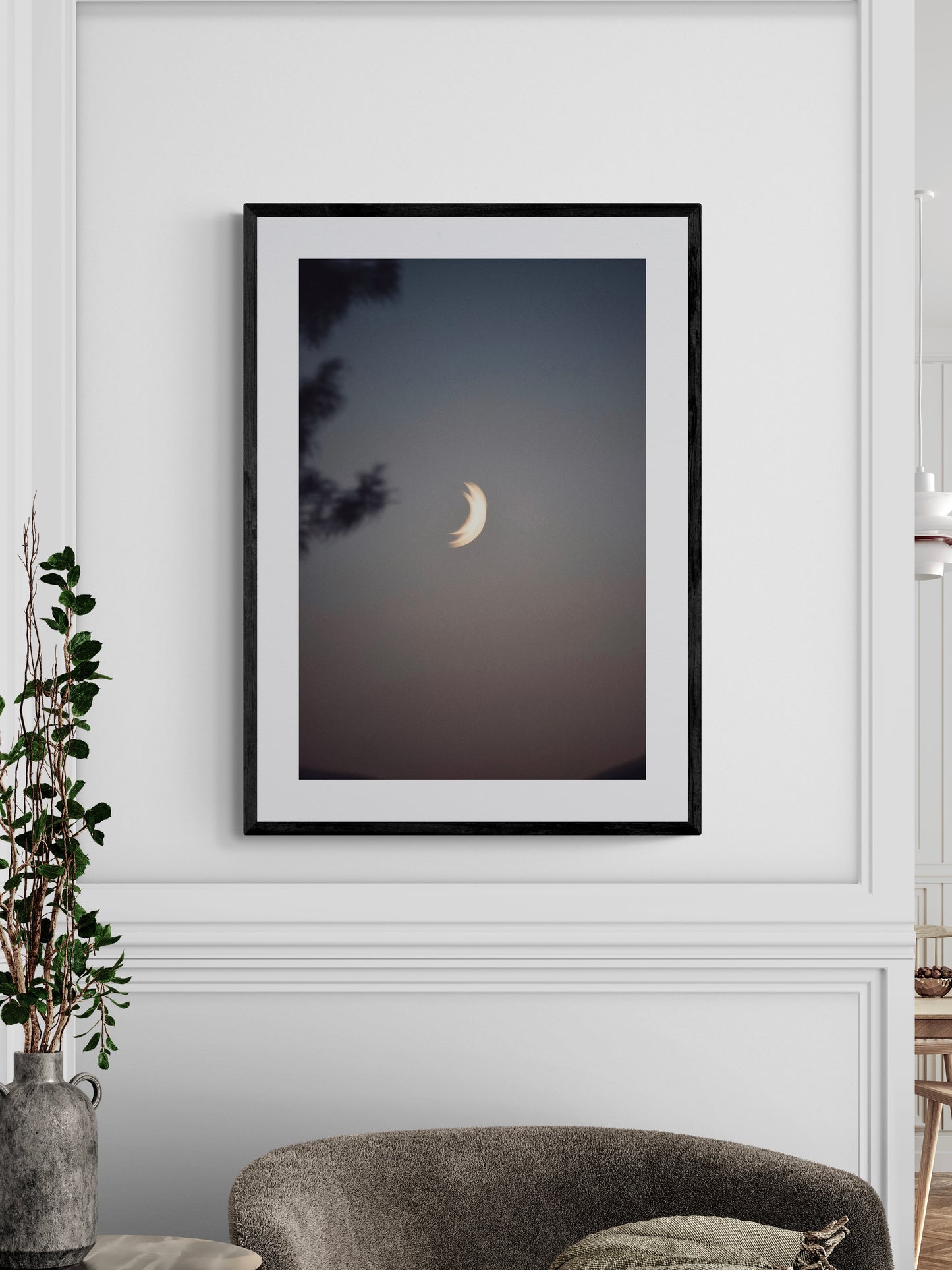 Framed photography print of "Two Moons" hanging on a wall, showcasing a serene twilight scene with a crescent moon.