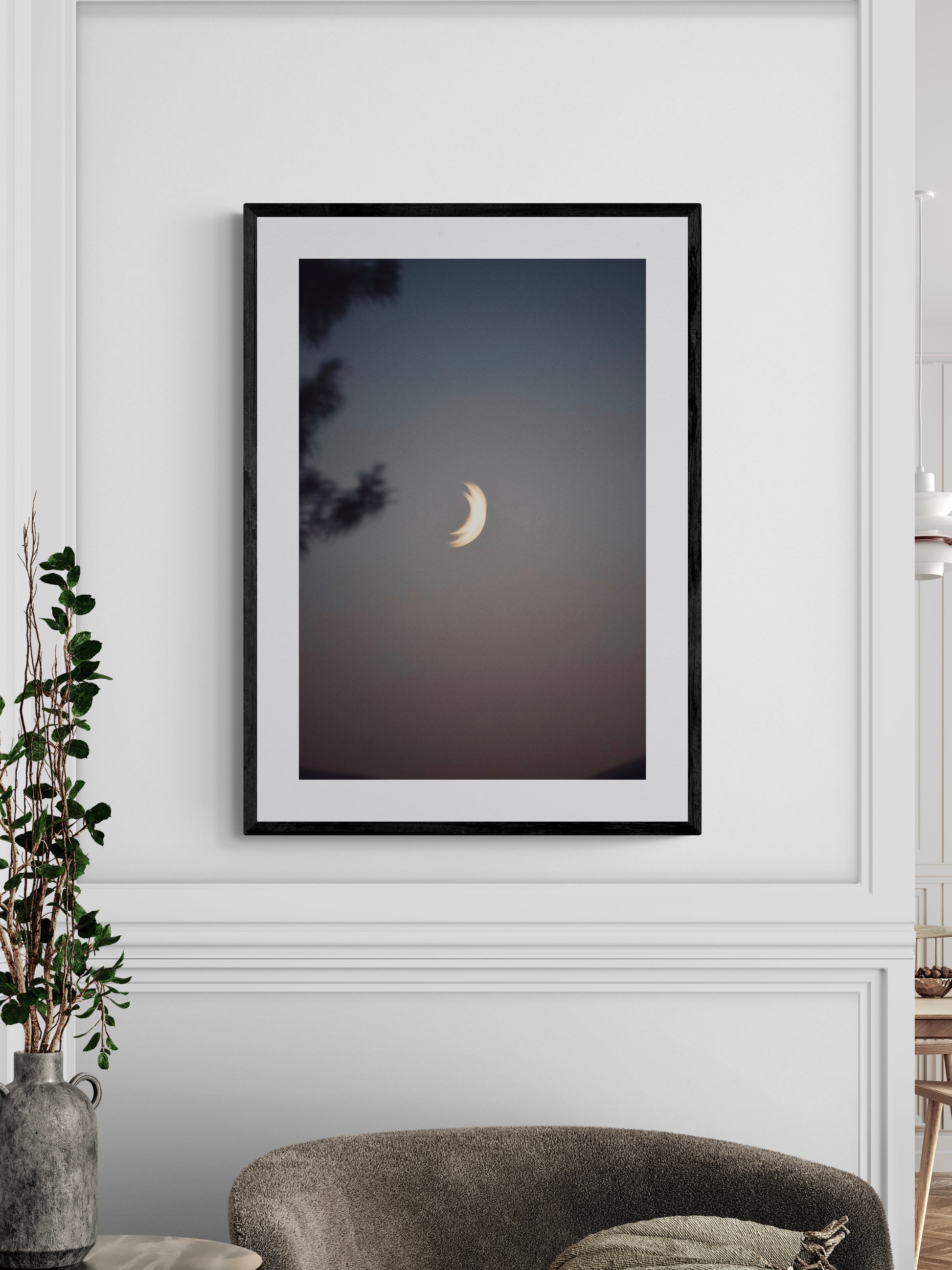 Framed photography print of "Two Moons" hanging on a wall, showcasing a serene twilight scene with a crescent moon.